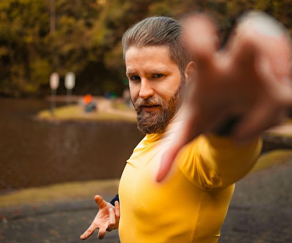 Man stretching outdoors with a serene natural background.